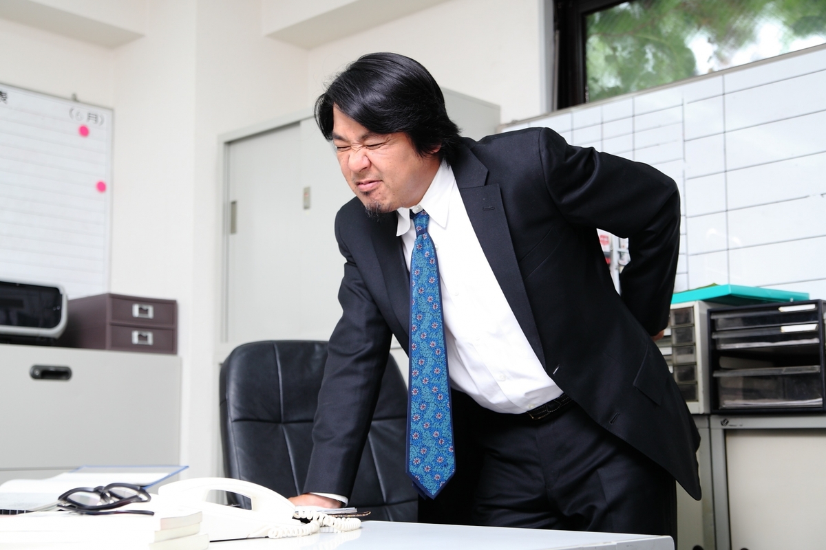 前かがみの腰痛の男性