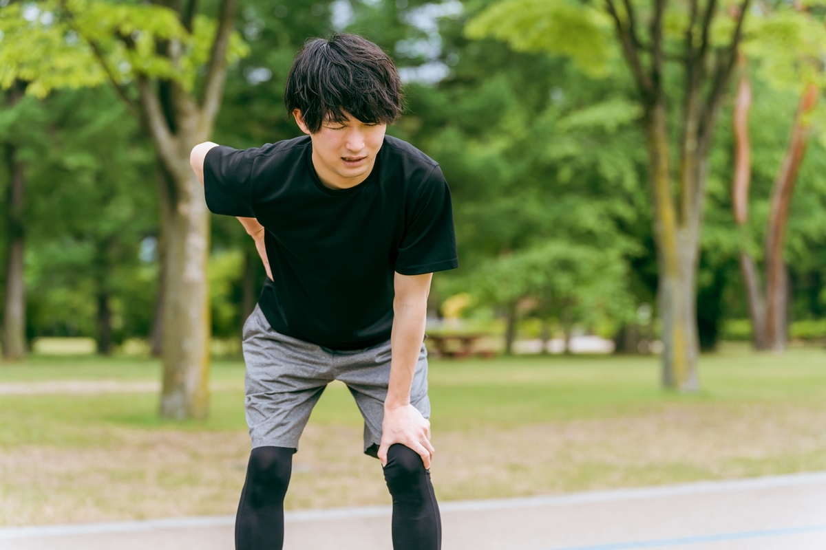 運動中に腰を抑える男性