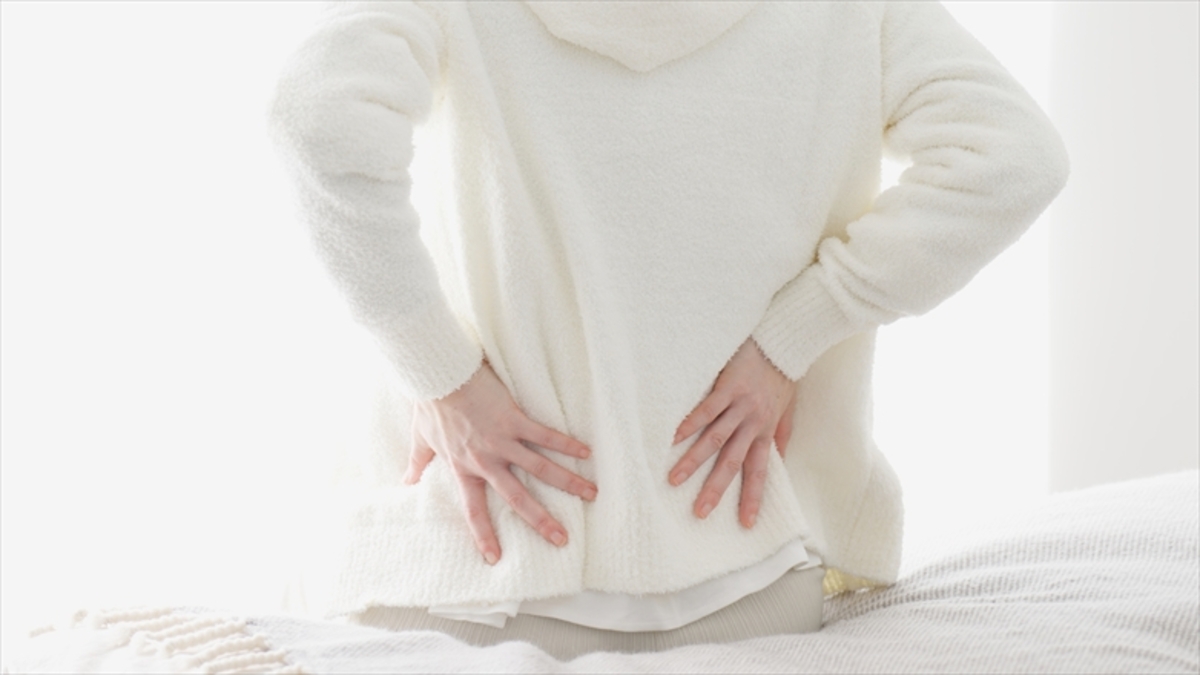 腰に手を当てている女性