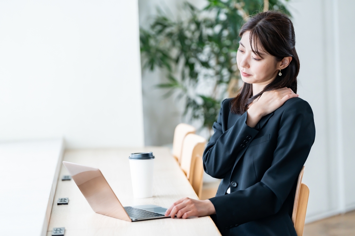 パソコン作業で肩こりに悩む女性